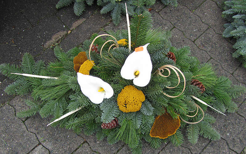 Ein Adventsgesteck mit Tannenzweigen und Blume